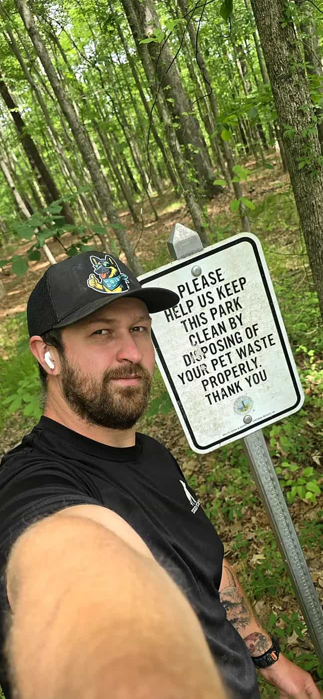 Pet waste cleanup education sign near a local green space