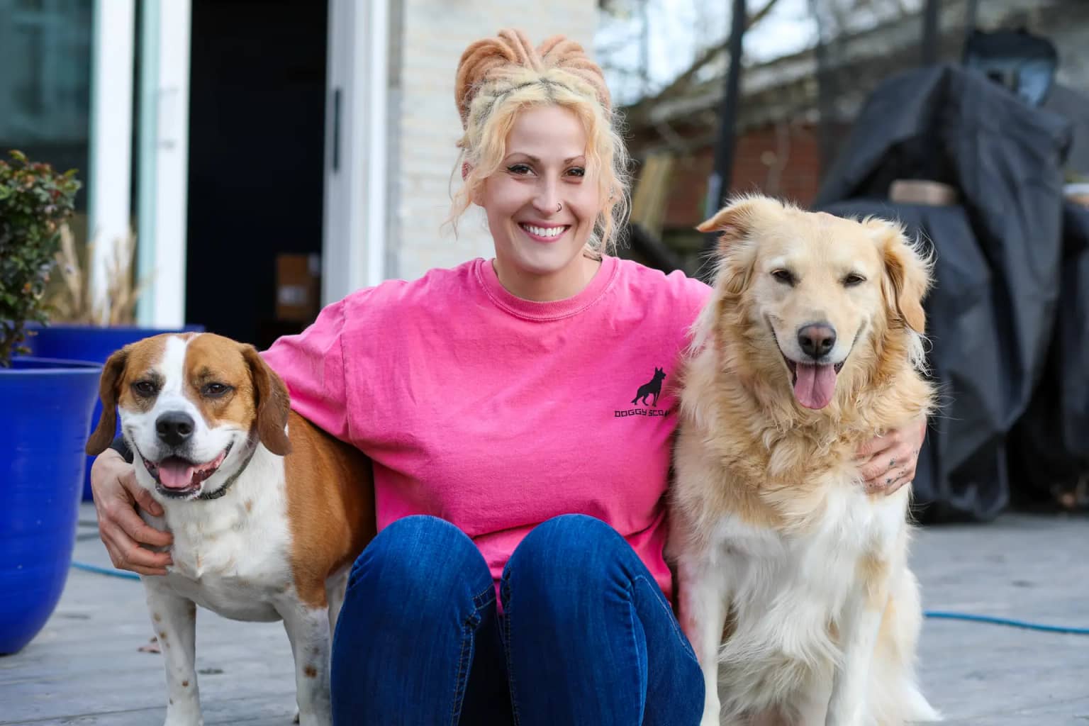 Doggy Scoop team member sitting with two dogs