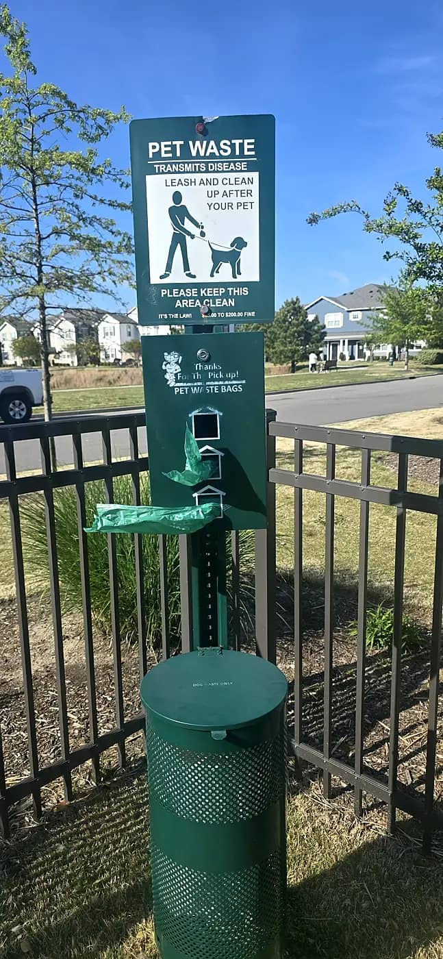 HOA and apartment pet waste station maintenance Pet waste station near a fenced community area